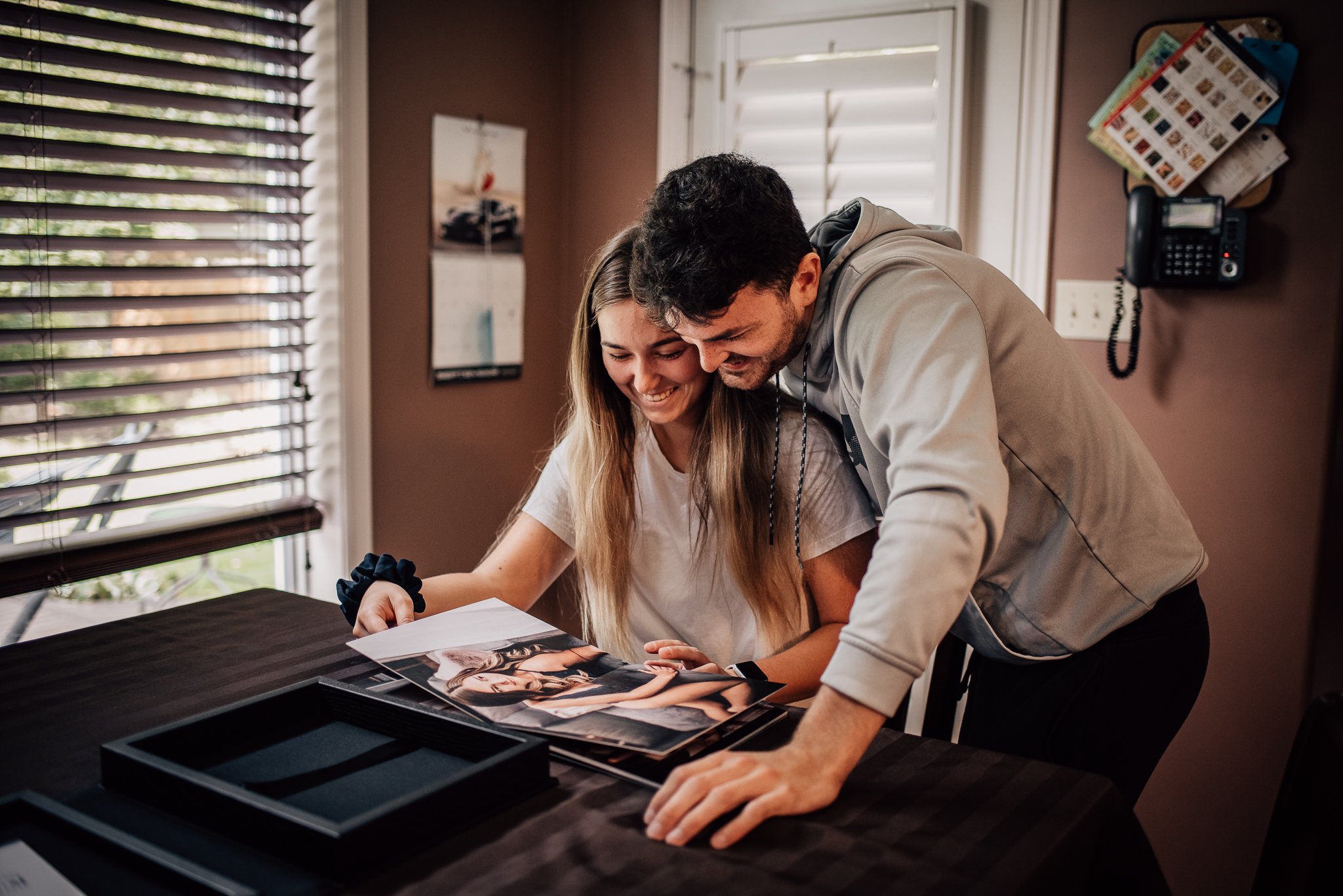 Woman showing her partner the sexy photos gift she bought him.