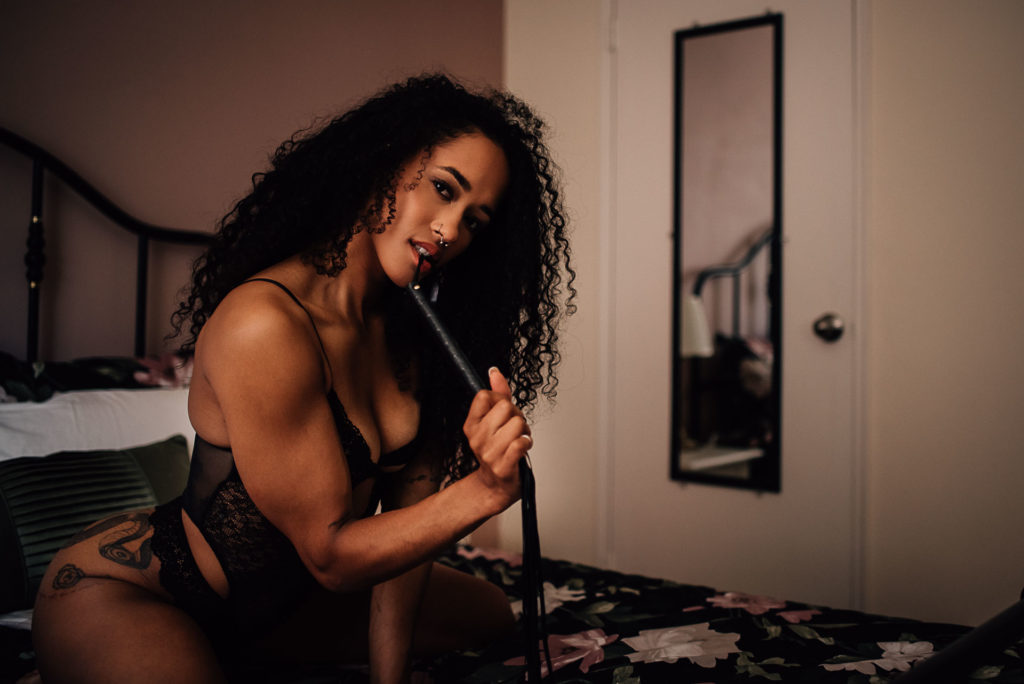 woman posing with whip for boudoir photo shoot