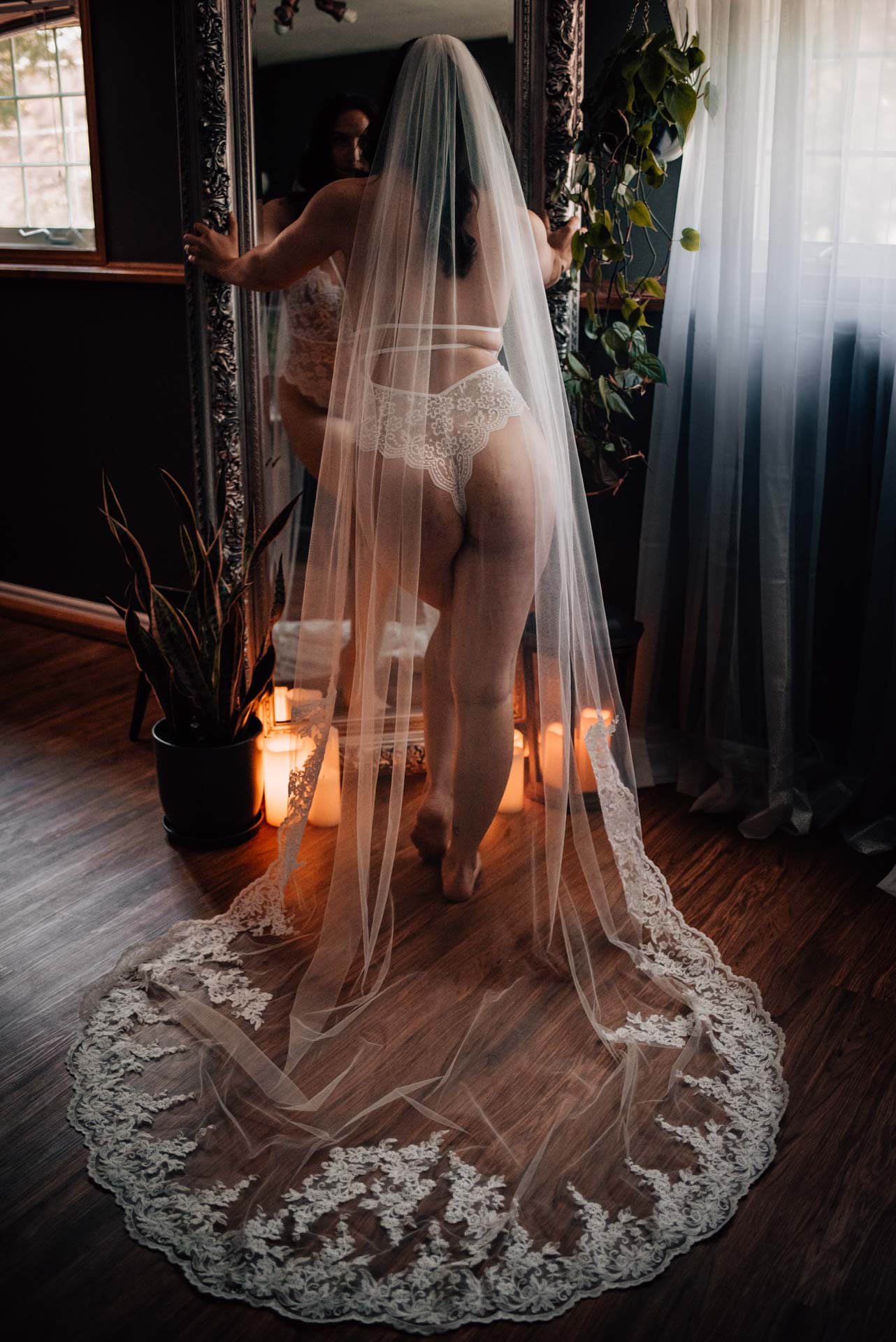 bride wearing cathedral length veil during bridal boudoir session