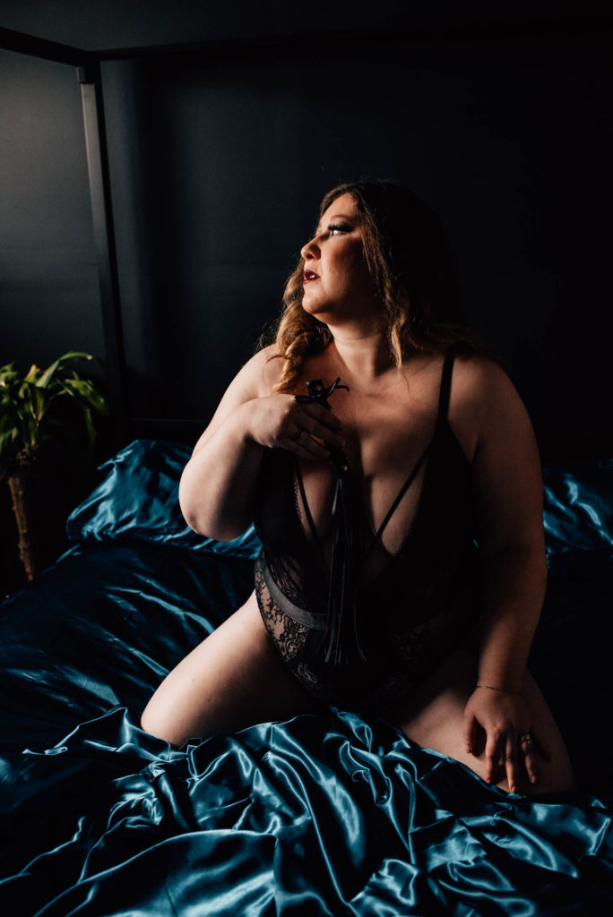 woman posing with flogger for boudoir session